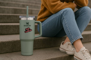 Person sitting on steps with a Stanley tumbler