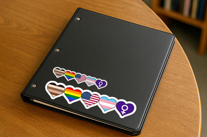 Black tablet with pride-themed stickers on a wooden surface