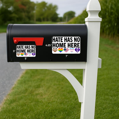 Black mailbox with 'Hate Has No Home Here' stickers on a grassy area.