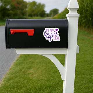 In My Feminine Rage Era purple feminist statement sticker displayed on the side of a black suburban mailbox.