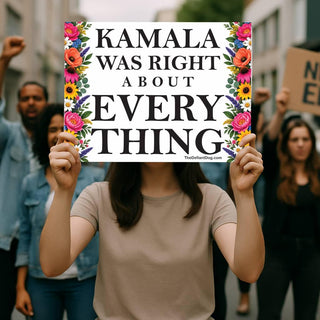 Person holding a Kamala Was Right About Everything floral protest sign at an outdoor political demonstration.