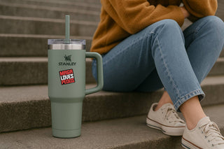 Person sitting on steps with a Stanley tumbler and 'Maga Loves Pedos' sticker.