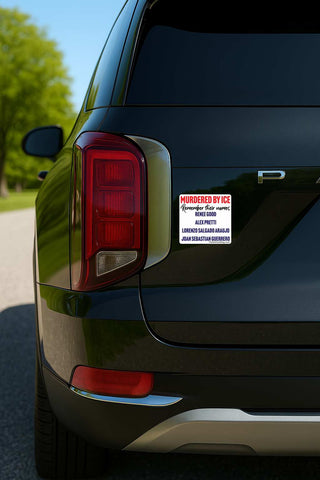 A close-up rear view of a black SUV outdoors, showing a white rectangular sticker on the left side of the trunk with red and black text that reads 'MURDERED BY ICE'.