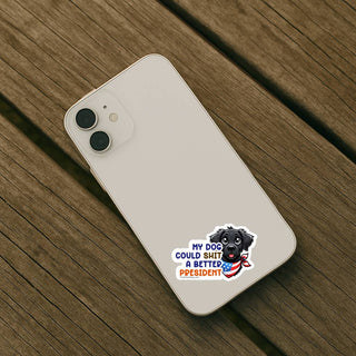 Light colored iPhone placed on wooden surface with My Dog Could Shit a Better President vinyl sticker on back of phone
