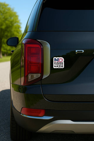 Car with a humorous sticker on the back, outdoors.