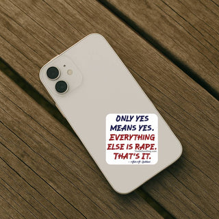 Consent awareness sticker reading Only Yes Means Yes Everything Else Is Rape That’s It applied to the back of a white iPhone on a wooden table.