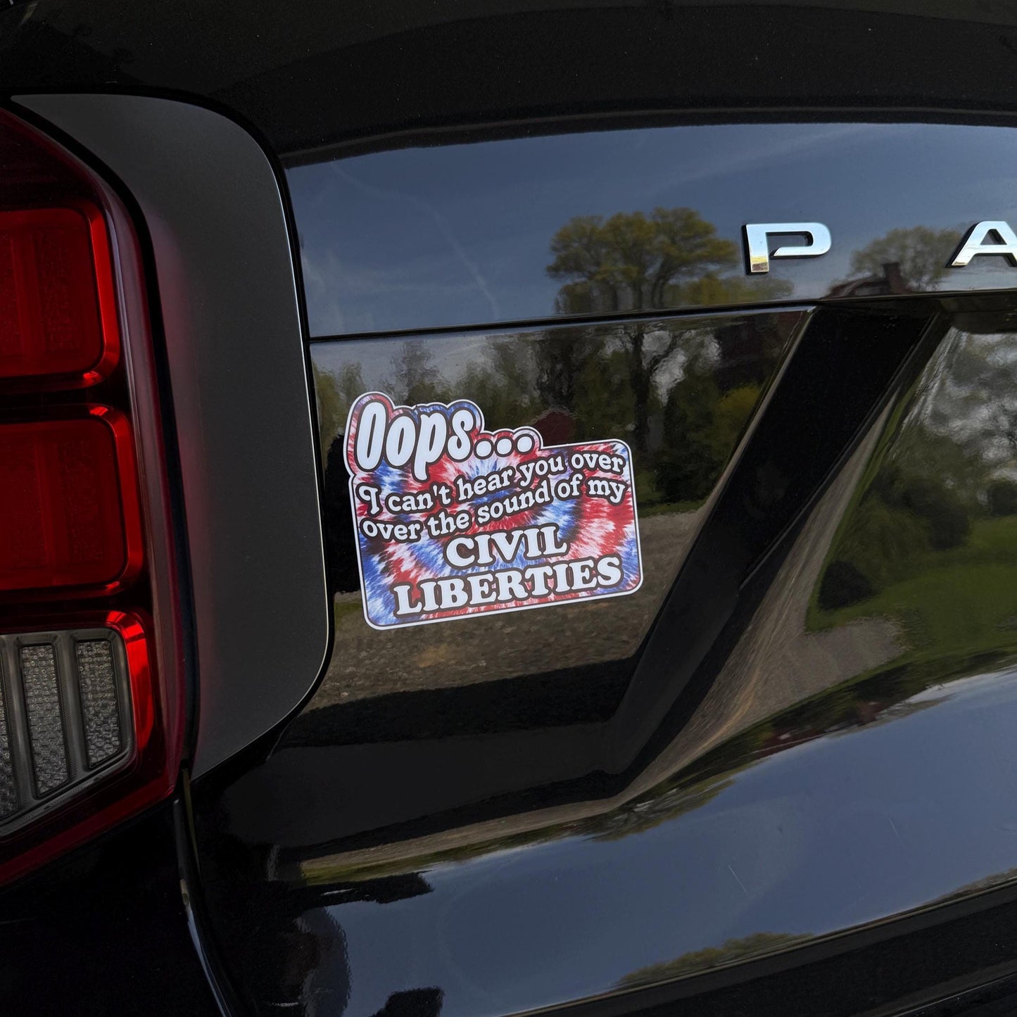 A colorful tie-dye magnet or vinyl decal with bold black text that says "Oops I Can't Hear You Over the Sound of My Civil Liberties," designed for cars, laptops, and more.