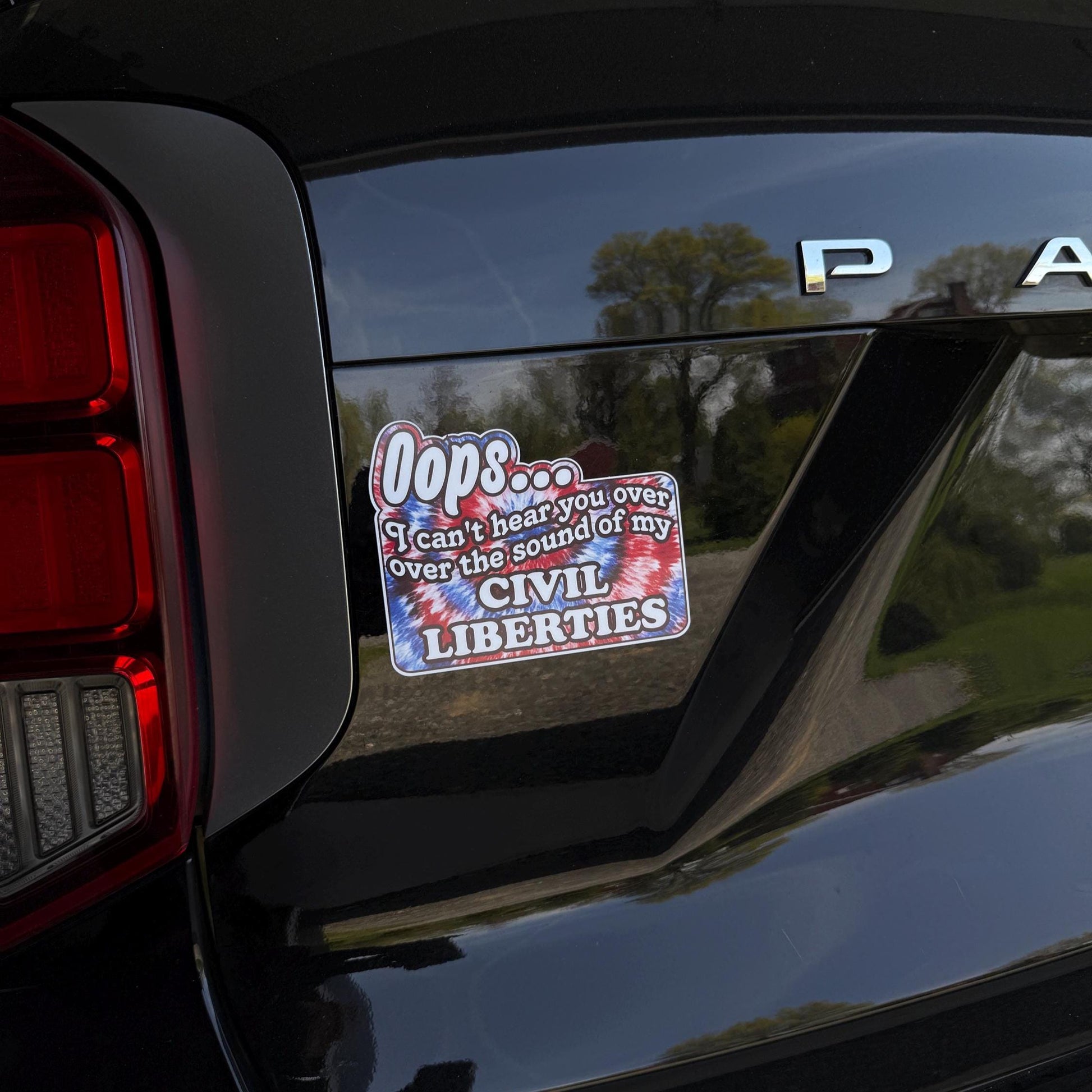A colorful tie-dye magnet or vinyl decal with bold black text that says "Oops I Can't Hear You Over the Sound of My Civil Liberties," designed for cars, laptops, and more.