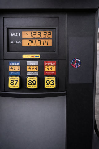 Close-up of a black gas pump display showing sale price, gallons, and three fuel options: Regular 87, Plus 89, and Premium 93.