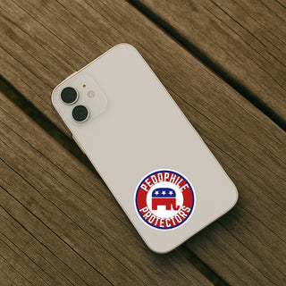White smartphone on wooden surface with Pedophile Protectors GOP sticker applied to back, anti Republican political vinyl decal mockup for phone