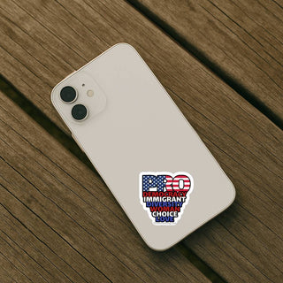An overhead view of the sticker placed on the back of a cream-colored iPhone, which is resting on a weathered wooden picnic table.