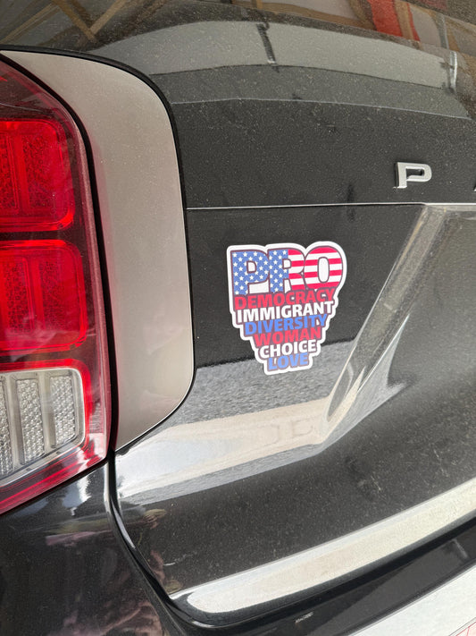Red, white, and blue "PRO" democracy vinyl decal displayed on the back of a black SUV near the taillight.