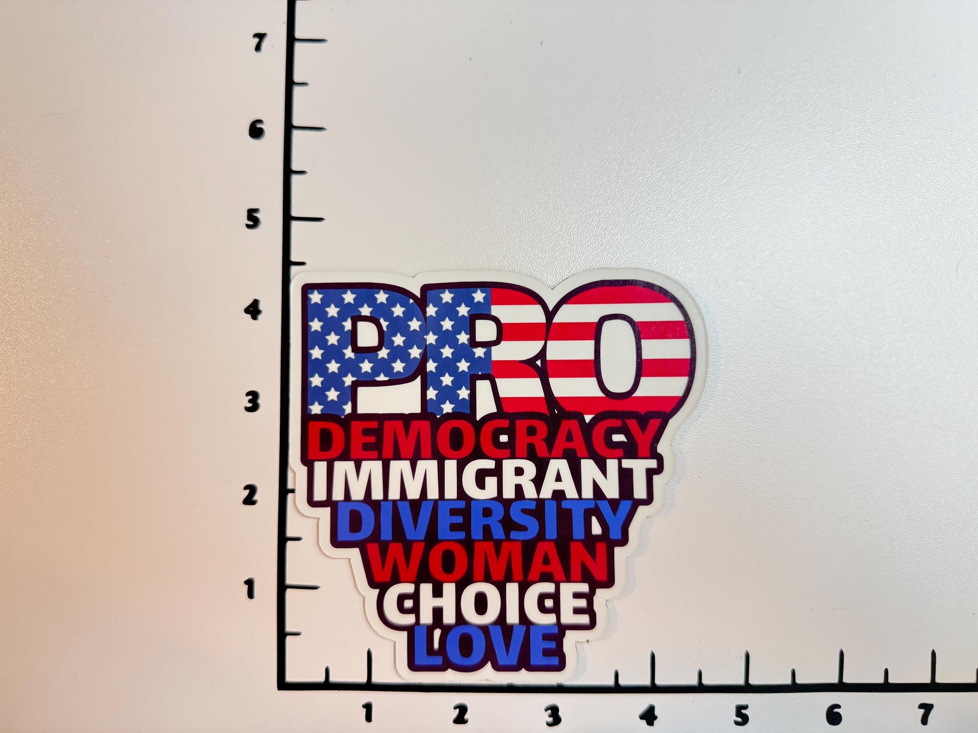 "PRO" red, white, and blue decal placed against a white background with black grid marks for size reference.