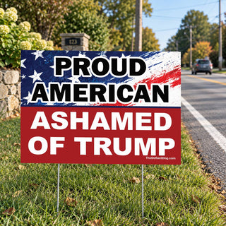 Proud American Ashamed of Trump anti-Trump political lawn sign displayed beside a residential road on metal yard stakes.