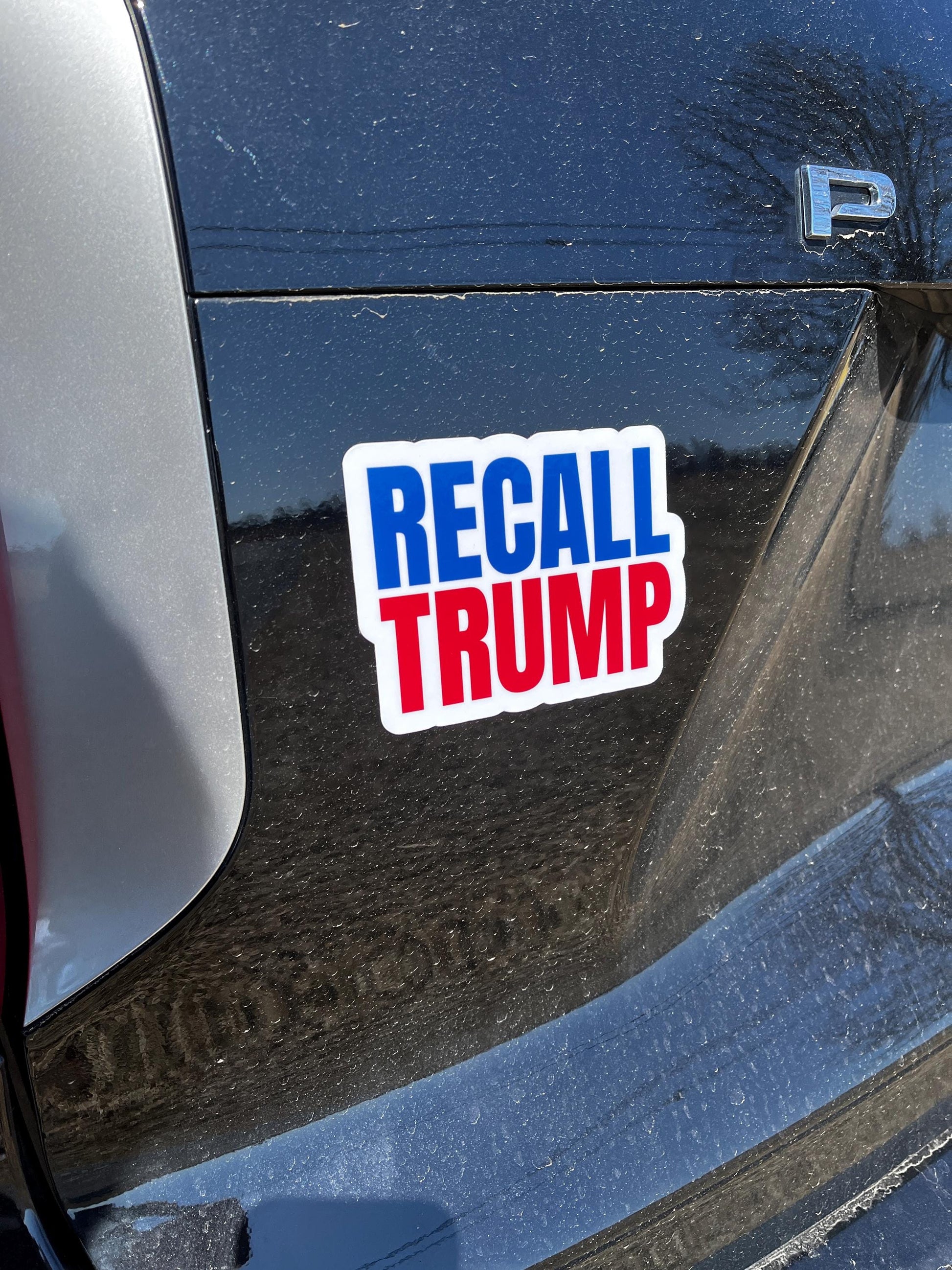 Recall Trump magnet displayed on the back of a car, demanding accountability and political change.