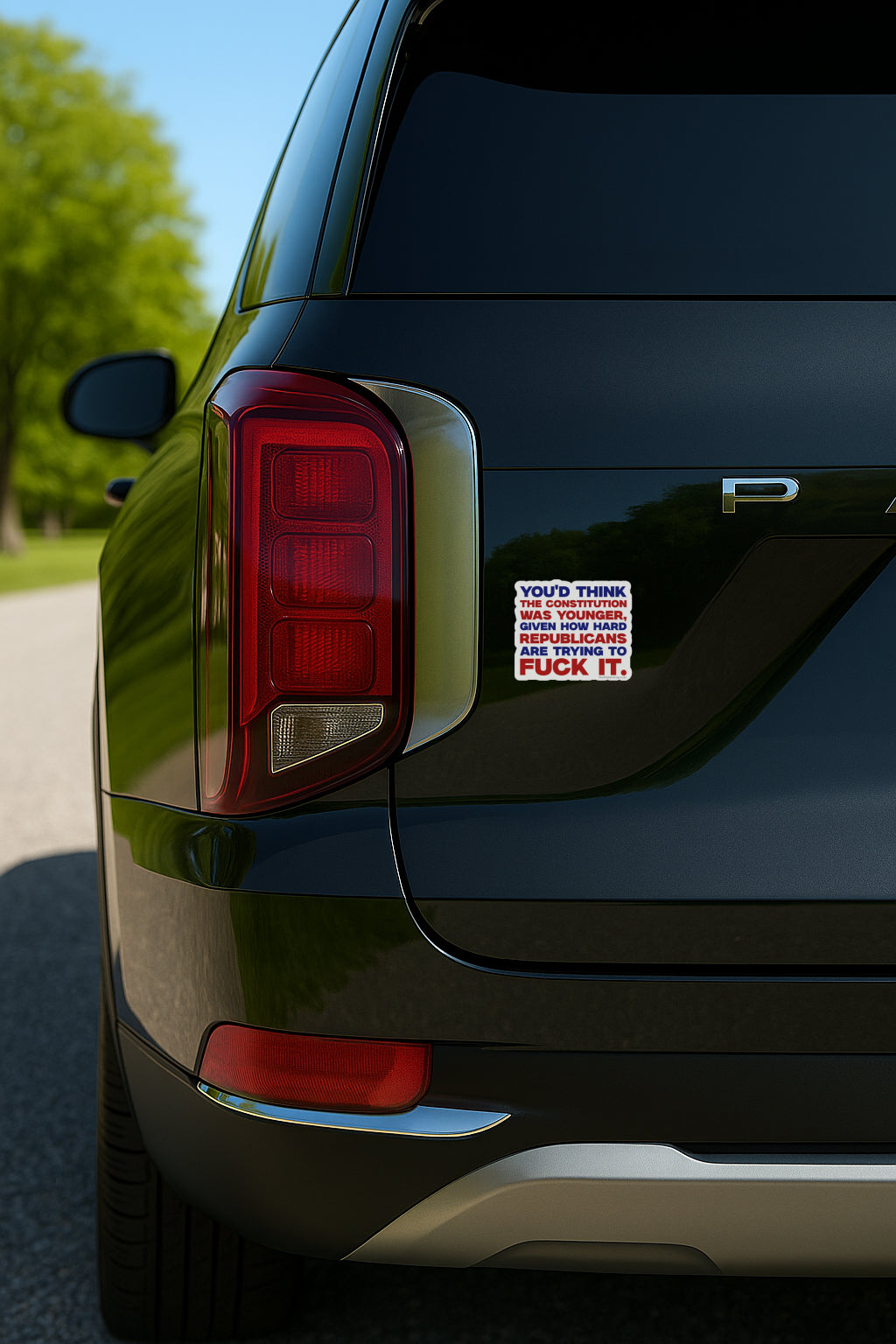 Back of a black SUV with a colorful sticker on the trunk