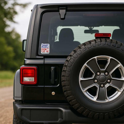 Black Jeep with a tire on the back, featuring a humorous sticker that has the quote from Donald Trump that says "smart people don't like me" on the rear window.