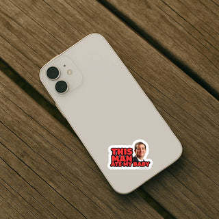 This Man Ate My Baby Ted Cruz sticker applied to the back of a light colored smartphone on a wooden surface.