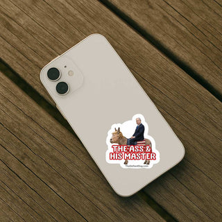 A white smartphone case shown from the back, placed on a brown wooden surface. The case has a printed sticker near the lower right featuring a photo of a man riding a horse with the text 'THE ASS & HIS MASTER' in red and white.