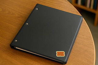 Black notebook with a logo on a wooden table