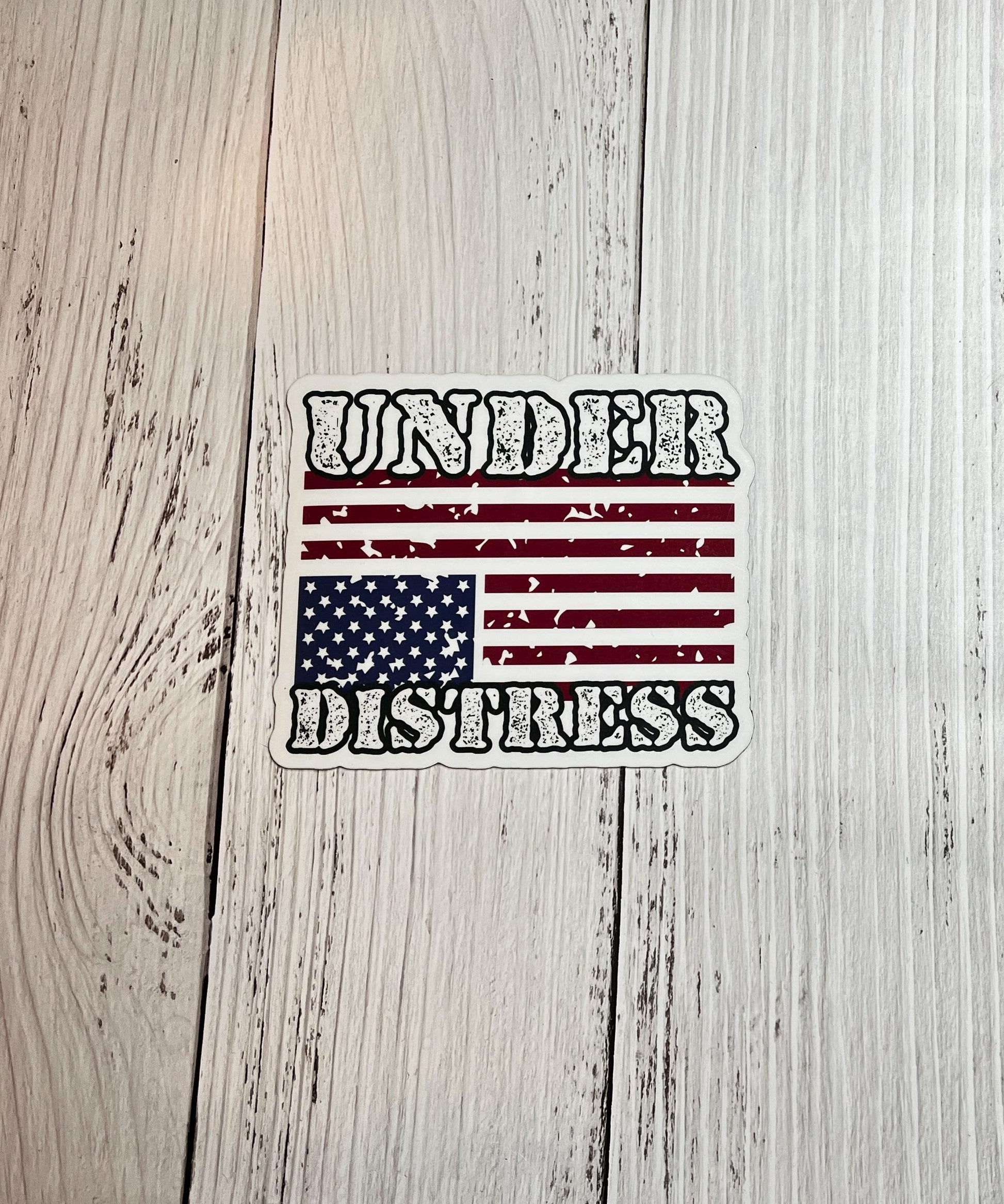 Under Distress magnet displayed on a table with an upside-down American flag, signaling a call for action in defense of democracy.