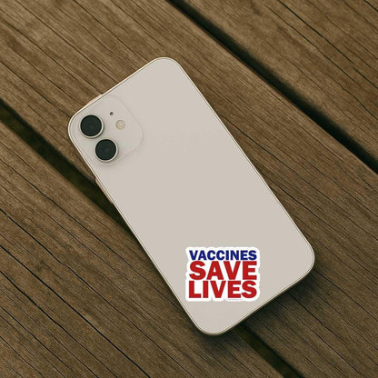Phone with 'Vaccines Save Lives' sticker on a wooden surface