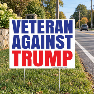 Veteran Against Trump anti-MAGA lawn sign displayed on metal stakes beside a suburban street, featuring patriotic red and blue lettering and a veteran political protest message.