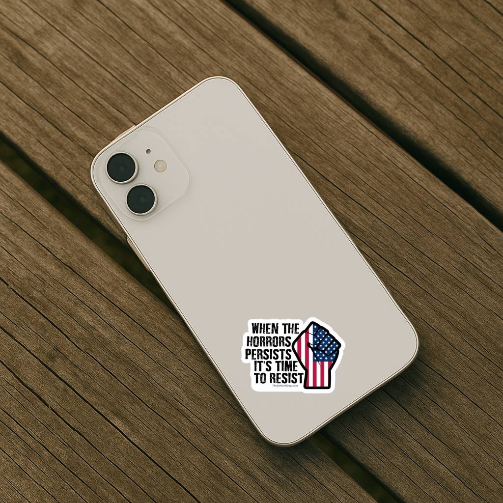 The sticker is placed on the lower back of an off-white or cream-colored smartphone. The phone is resting diagonally on a weathered wooden surface.