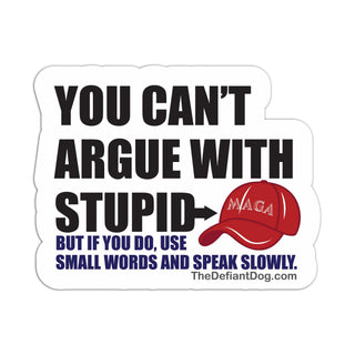 A die-cut white sticker with bold black text reading 'YOU CAN'T ARGUE WITH STUPID' and a red cap illustration with 'MAGA' on it. Smaller blue text below says 'BUT IF YOU DO, USE SMALL WORDS AND SPEAK SLOWLY.