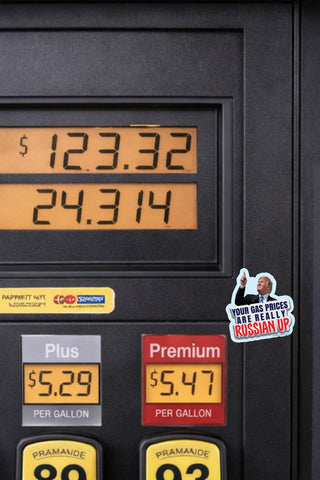 Your Gas Prices Are Really Russian Up anti-Trump sticker featuring Donald Trump pointing upward, displayed on a gas pump beside illuminated gasoline price displays.